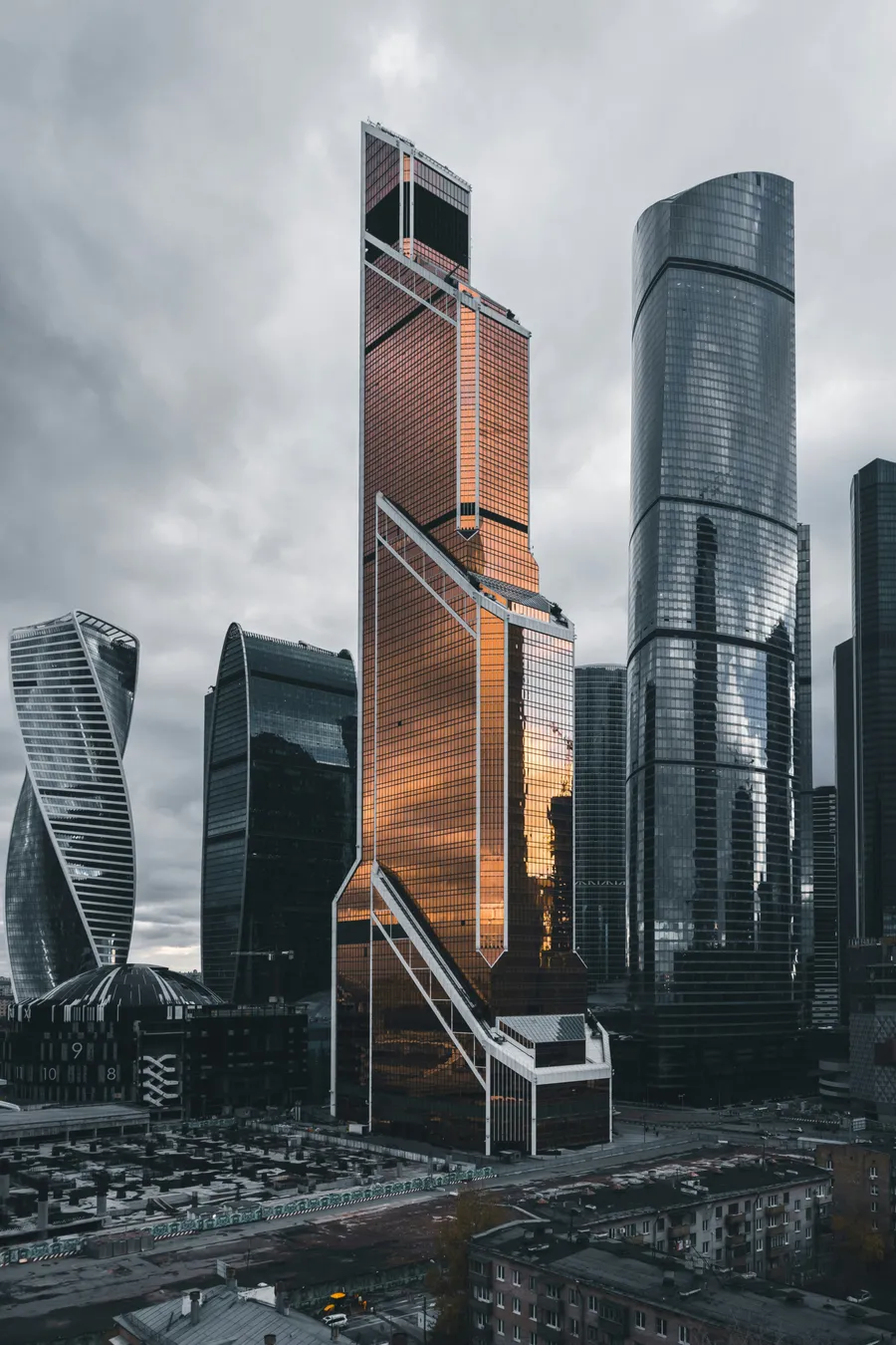 A cluster of glass high-rise towers under a cloudy sky