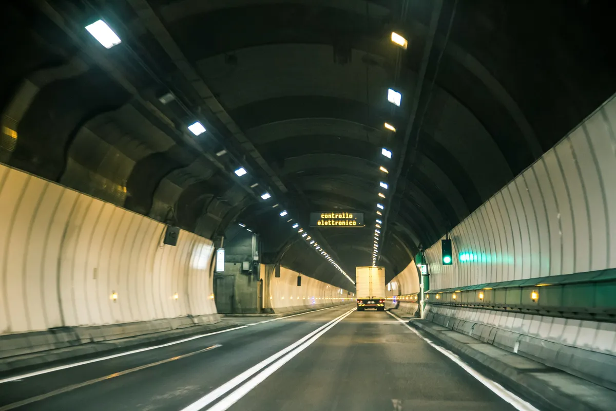 Inside a lit road tunnel with a lorry ahead